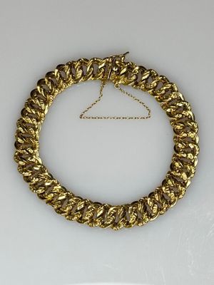 a close up of a gold necklace on a white surface