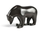 une figurine d'ours noir posée sur une surface blanche