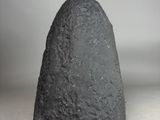 an image of a black rock sitting on top of a white surface
