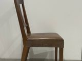a wooden chair with a leather seat on a tile floor