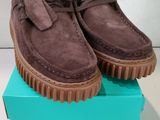 les chaussures se trouvent dans une boîte posée sur une surface blanche