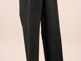 le pantalon est noir et gris, avec une chemise blanche, présenté sur un mannequin