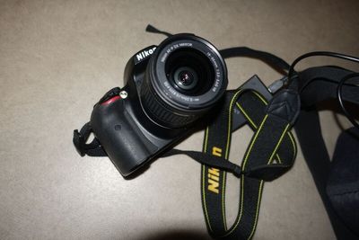a camera that is sitting on a table next to a camera strap