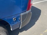 a blue truck parked in a parking lot next to a fence
