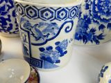 several blue and white china dishes and cups on a white table
