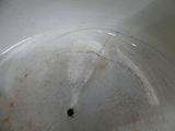 a dirty sink with a drain in the middle of it