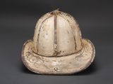 an old fireman ' s helmet on a black background