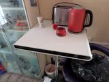 a small table with a red kettle on top of it