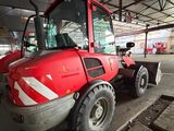 a red tractor that is parked inside of a building