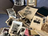 une pile de vieilles photos posée sur un lit, avec un parapluie