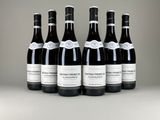 six bouteilles de vin sont alignées sur une table