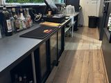 une photo d'un bar avec un comptoir et une télévision