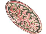 une assiette rouge et verte ornée d'un motif floral