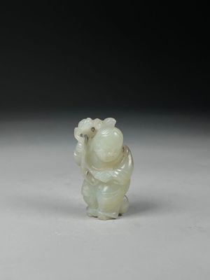 chinese carved jade figurine of a monkey holding a flower