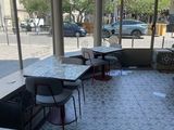 tables and chairs in a restaurant with a view of the street