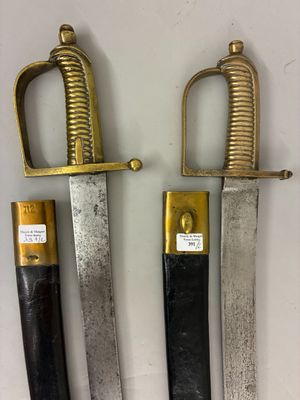 two old swords are on display on a white surface