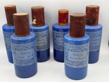 six bottles of blue and brown perfume sitting on top of a white surface