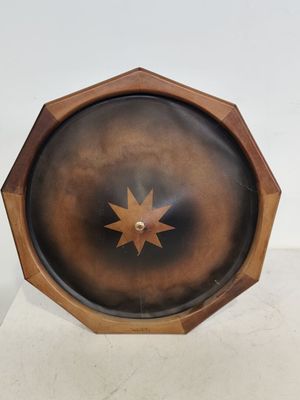 une horloge en bois ornée d'une étoile, posée sur un socle
