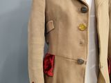 an image of a woman ' s coat with red velvet cuffs on a mannequin
