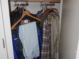 an image of a closet with clothes hanging on a rack