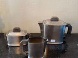 trois cafetières et deux tasses sur le plan de travail