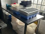 a kitchen with a table with buckets and containers on it
