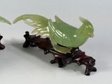 two figurines of birds sitting on a table