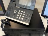 a black telephone sitting on top of a desk next to a computer monitor