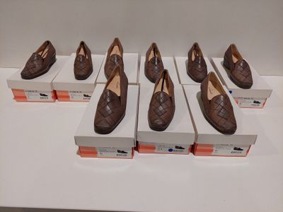 Six paires de chaussures marron sont exposées dans une vitrine.