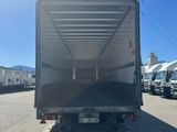 the back of a truck parked in a parking lot next to other trucks