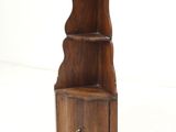 a small wooden shelf with a bell hanging from it