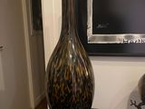 a black table with a vase on it next to a picture
