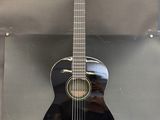 Une guitare acoustique est exposée dans une vitrine.