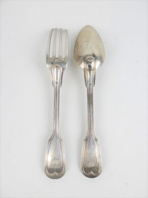 deux cuillères et une fourchette sur une surface blanche