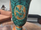 a green vase sitting on a table in a living room