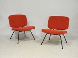 une paire de chaises longues orange aux pieds noirs