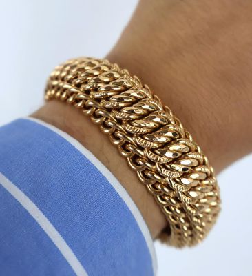 a close up of a person ' s arm wearing a gold chain bracelet