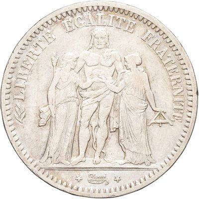 a close up of a silver coin with a statue on it