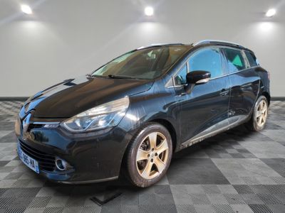 une voiture noire est garée dans une pièce au sol en damier