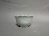 a white bowl sitting on a table with a white background