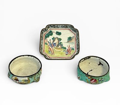 Trois pièces de poterie chinoise sont posées sur une surface blanche