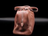 a brown leather handbag with a zipper on the side