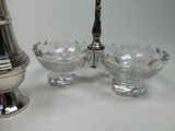 a silver vase and a silver sugar shaker on a table