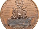 an image of a bronze medal with a coat of arms and a crown on it