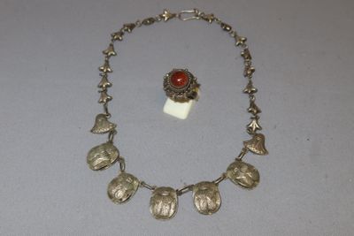 silver necklace and earrings with red stone on display on a table