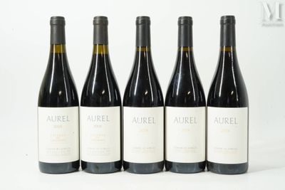 quatre bouteilles de vin sont alignées sur une surface blanche