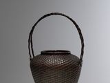 brown wicker basket with handle on a white surface