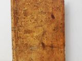 an old book sitting on top of a table next to a white wall