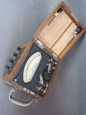 un coffret en bois contenant un compteur, posé sur une table