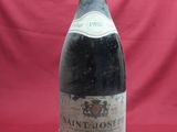 an old bottle of wine sitting on a red surface